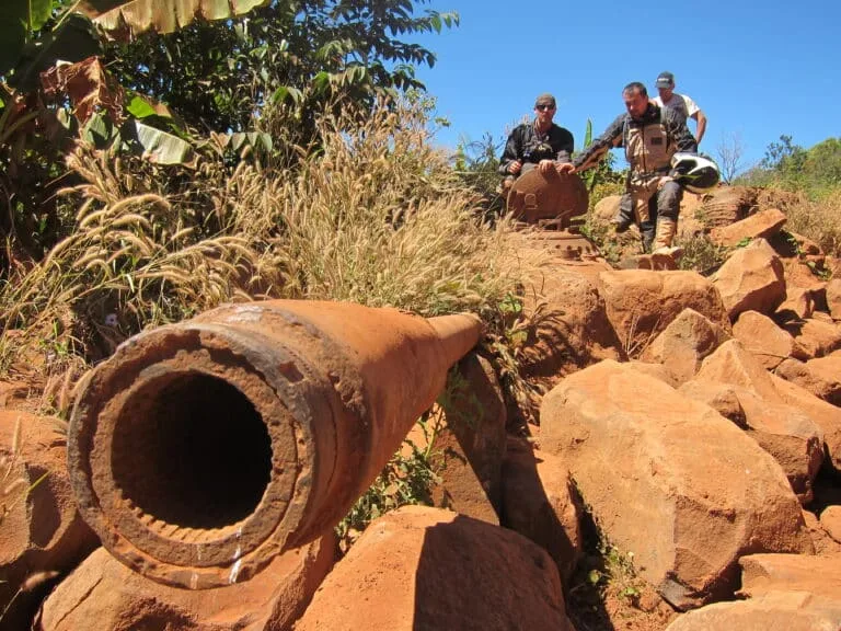 Explore Indochina riders on a ruined tank on the Ho Chi Minh Trail in Laos