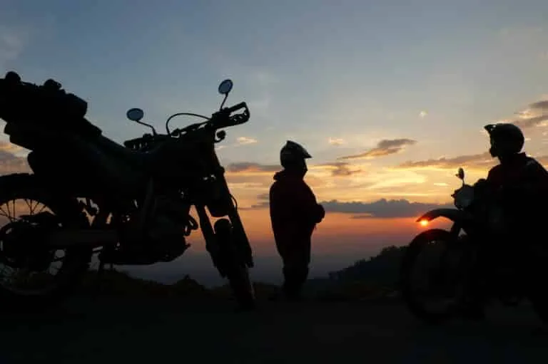Motorcycle tour riders enjoy sunset on the Ho Chi Minh Trail in Laos